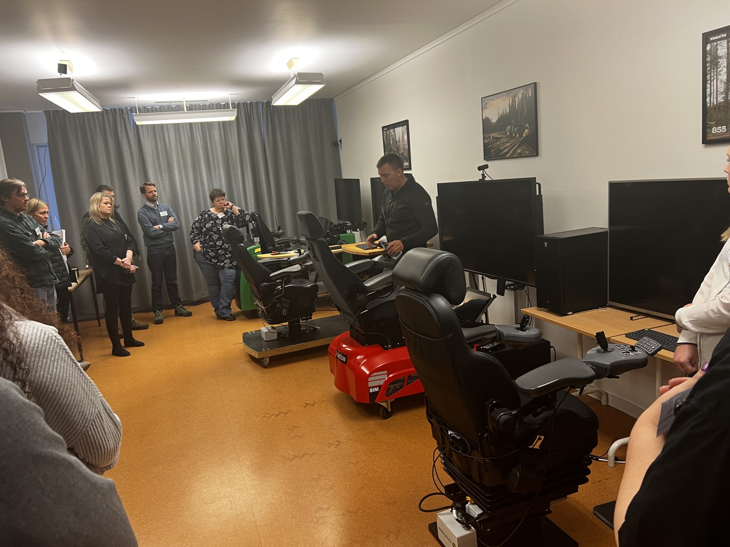 En grupp med människor som tittar på simulatorer.